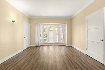an empty living room with doors and a window